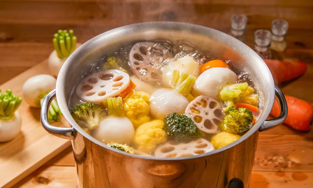 Boiling vegetable soup with lotus root, broccoli, and other veggies at The Imperial Treasure, a Chinese restaurant in Matthews