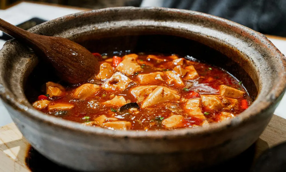 Spicy mapo tofu simmering in a stone pot with red chili oil at The Imperial Treasure, a Chinese restaurant in Matthews